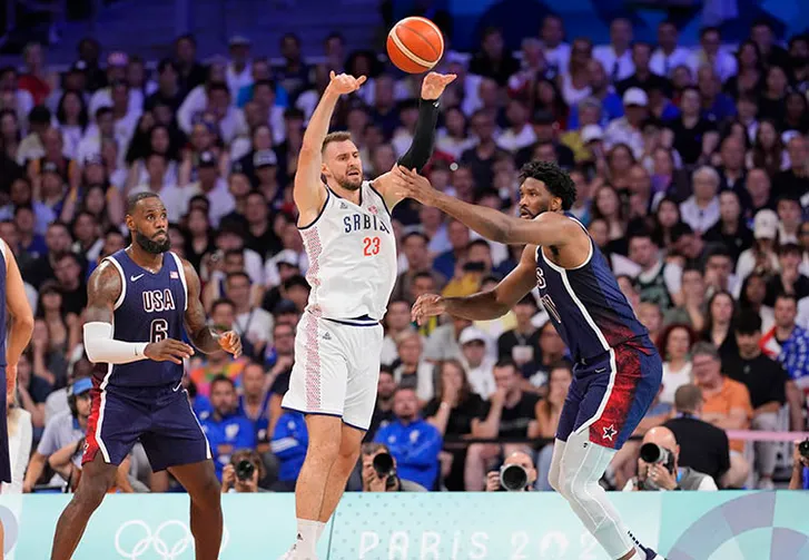 Serbia shooting guard Marko Guduric (23) passes against United States guard Lebron James (6) and center Joel Embiid (11) in the second quarter against Serbia during the Paris 2024 Olympic Summer Games at Stade Pierre-Mauroy.