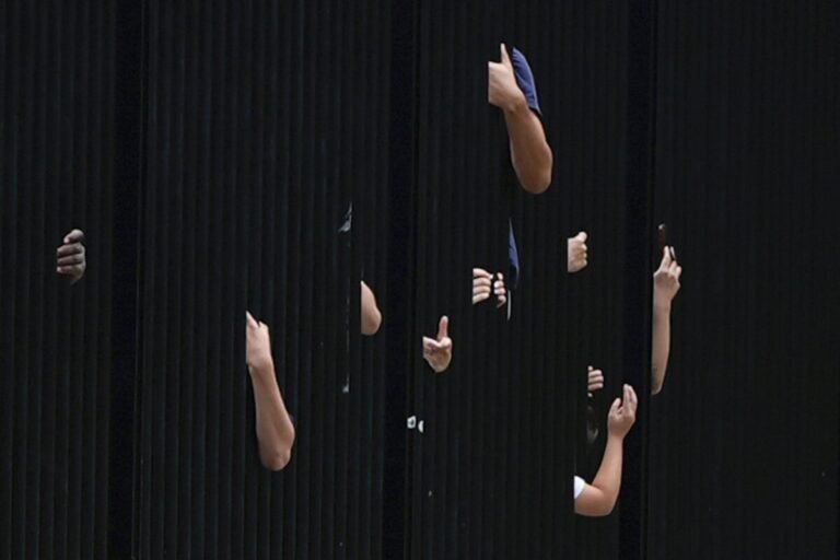 July 23, 2024 | Washington, D.C. | Visitors reach through the White House fence.