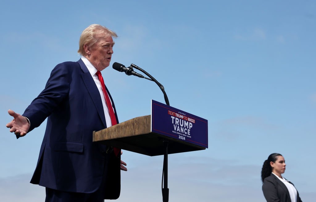 Former U.S. President Donald Trump speaks as a Secret Service agent stands guard at a press conference in Rancho Palos Verdes, California, on Sept. 13.